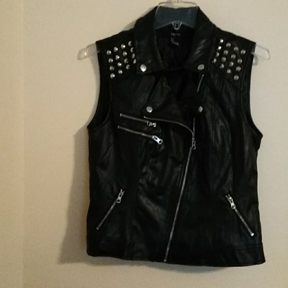 Black spiked studded vest with multiple zippers.